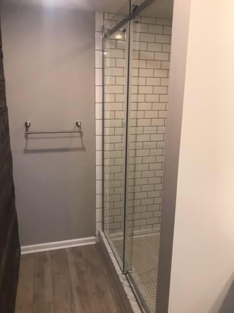 bathroom shower with gray wall and tiled shower