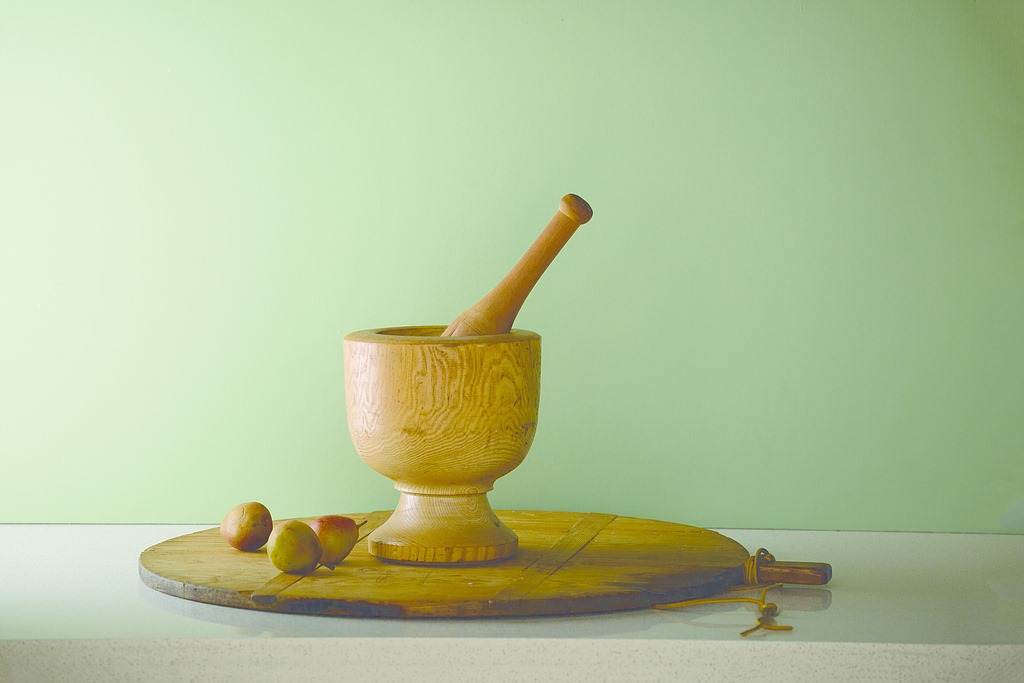 Green wall with mortal and pestle wooden